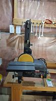 Full view of Craftsman belt and disc sander showing sanding belt in vertical orientation, sanding disc in front, on a wooden workbench.