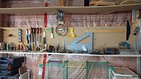 Shelf of assorted hand tools on pegboard shelf
