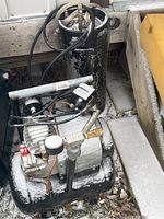 Image showing Mastercraft air compressor alongside the black CO2 tank with snow on surfaces and visible pressure fittings.