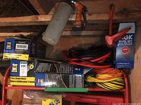 Overall view of lot on red shelving showing Power Fist hoist boxes, coiled cables and NGK wire set