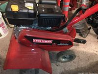 Left side of tiller showing red side shield, small wheel and Craftsman decal