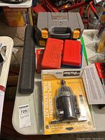 Overview photo showing assembled lot with Parker Racor fuel filter kit in front, various tool cases behind including red metal socket extractor set and gray Jobmate wrench set case.