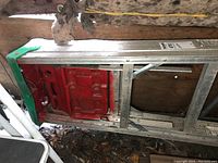 Top view of the ladder showing the green and red base components and aluminum frame.