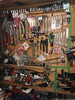 Full view of pegboard displaying assorted wrenches, ratchets, sockets, gauges and other hand tools