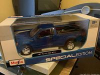 Boxed Maisto 1:27 Ford F-150 STX blue diecast truck in Special Edition packaging.