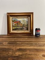 Framed painting of barn and landscape with Pepsi can for scale