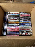 Top view of a box filled with multiple DVDs showing titles and arrangement