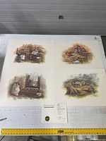 Four art prints laid flat showing rustic interior and exterior Canadian heritage scenes, with Certificate of Authenticity centrally placed.