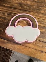 Rainbow and cloud shaped children's ceiling light fixture with cloud cover on top.