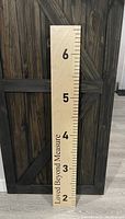 Full view of wooden height ruler showing measurements from 2 to 6 feet and the phrase 'Loved Beyond Measure'