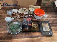 Full lot of assorted kitchen and decorative items arranged on floor showing bowls, pots, trays, incense sticks, and framed artwork.