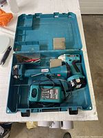 Open Kit with Makita cordless drill, flashlight, battery charger inside molded plastic carrying case