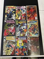 Nine Marvel comic books laid out including Defenders, Marvel Fanfare, Spider-Man, Hawkeye, Wolverine, and The Wall comics with full color action illustrations on covers.