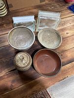 Overview of all pottery and glass blocks on wooden table showing size and texture contrast