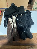 Four pairs of women's boots size 7.5 including black and brown styles, some with fur lining and zip closures.