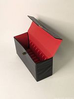 Open view of vintage 8-track tape leather carrying case revealing red interior lining and plastic slots for 8-track tapes.