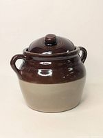 Front view of Monmouth Pottery bean crock with lid, showcasing the two-tone glaze and handles.
