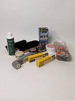 Lot of vintage shoe polish products, brushes, and leather treatment items arranged on white background