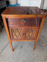 Front view showing radio cabinet drawer with tuning dial and speaker doors below with lattice design