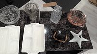Various thick glass vases, bowls, ceramic serving dishes, teapot, and decorative starfish on table showing full lot contents