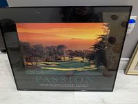 Photo of a framed motivational print featuring a golf course at sunset with the text 'PASSION' and a quote.