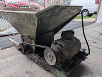 Side view of old electric grinder showing rusted metal hopper and motor