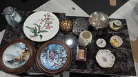 Overview of the assorted plates and decorative collectibles on marble surface