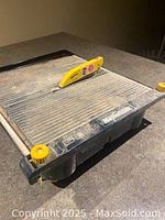 Side angle showing the saw blade with yellow guard and ribbed cutting platform surface on black frame.