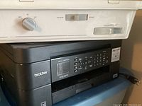 Side view of black Brother MFC-J487DW printer showing control panel with buttons and LCD screen