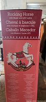Box showing image and text description of ceramic rocking horse with LED lights and music