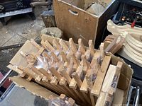 Box of mini wooden table top easels, individually plastic wrapped, stacked upright in a cardboard box