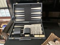 Photo of backgammon game set in case with dice and playing pieces arranged inside.