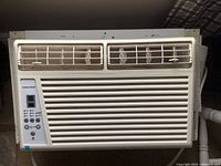 Front view of white Danby window air conditioner showing vent slats and electronic control panel on left.