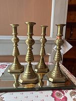 Front view of all four candlesticks on mirrored glass