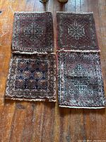 All four Persian prayer rugs laid out on wooden floor, showing varying designs and sizes