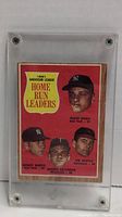 Full front of card in plastic screw-down holder showing all four player portraits and title badge