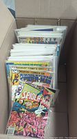 Photo of box with various comics inside, showing front covers of Spider-Man issues at the front.