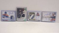 Four Edmonton Oilers hockey cards displayed in protective sleeves showing autographs and jersey patches.
