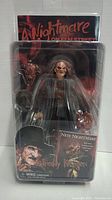 Front view of Freddy Krueger action figure packaged with Nightmare on Elm Street branding and included extra head.