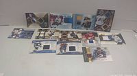 Full view of all 12 hockey cards laid out in front of a plain white background showing various jersey patch cards including single and dual patch cards.