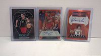 Three Panini Obsidian NBA basketball cards including Trae Young patch card, Torrey Craig autograph card, Jericho Sims autograph card, all in protective cases.