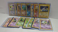 Front view of the lot of 16 First Edition Pokemon cards, showing a spread with variety of Pokemon.
