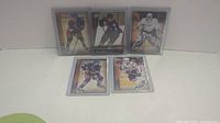 Five Upper Deck Youngguns rookie hockey cards in protective sleeves displayed on white surface.