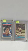 Front view of 1982 Dale Hawerchuk and 1974 Denis Potvin rookie hockey cards in screw-down hard plastic holders with 'Rookie Card' notes.