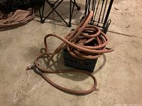 Coiled industrial strength hose on a crate in a garage setting