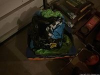 Inflatable slip and slide toy deflated and folded inside a box marked for mandarins, surrounded by storage items.