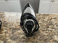 Front view of Sunbeam iron showing pointed soleplate and power cord wrapped around base