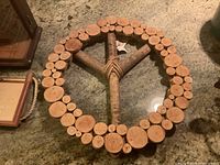 Front view of wine cork peace sign, showing round cork pieces on wooden frame