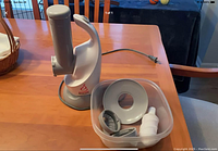 Desert Bullet juicer base and accessories arranged on a wooden table, showing all components included in the lot.