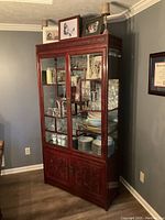Full view of tall rosewood hutch cabinet against wall, showing glass display upper doors and solid lower doors.
